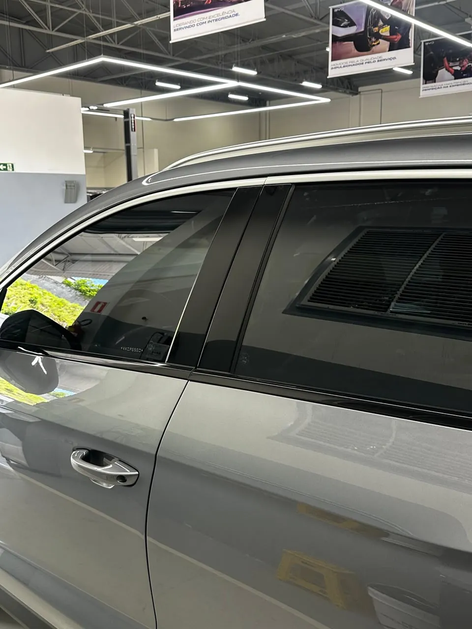 Detalhe dos vidros laterais de SUV cinza com película escura